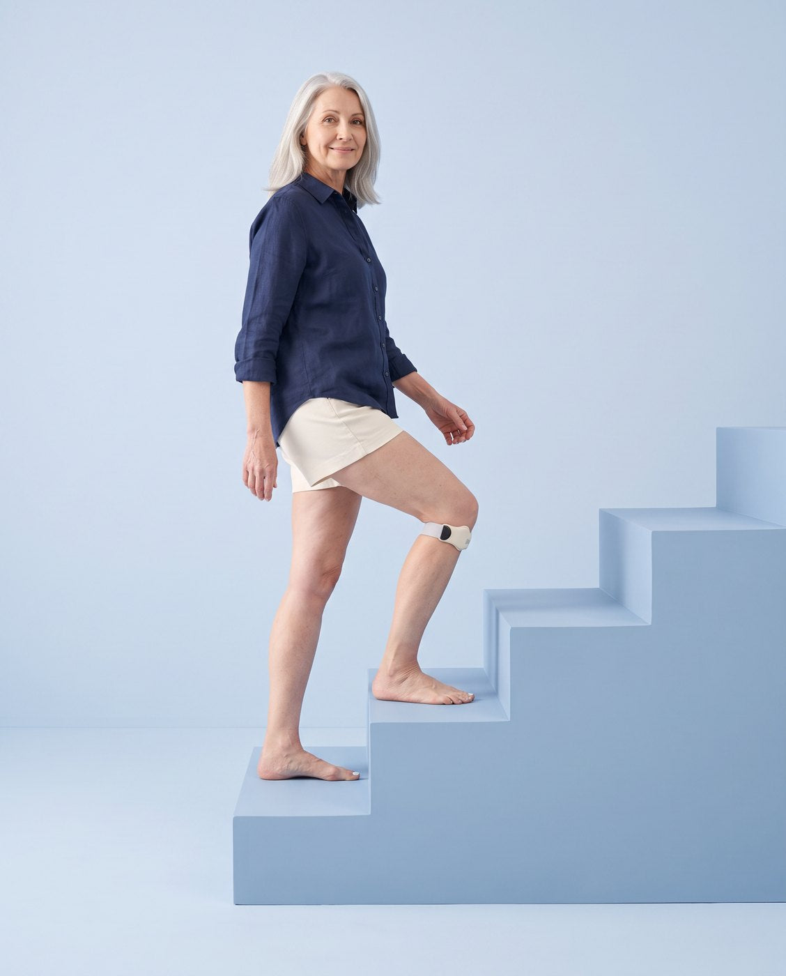A woman walking up a studio staircase wearing Bendio